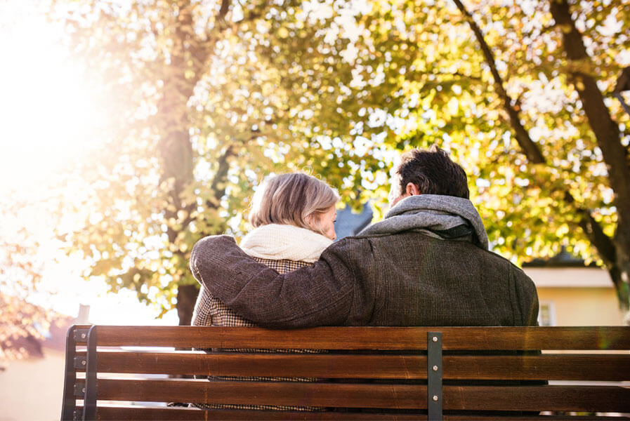 Retired couple sitting on bench